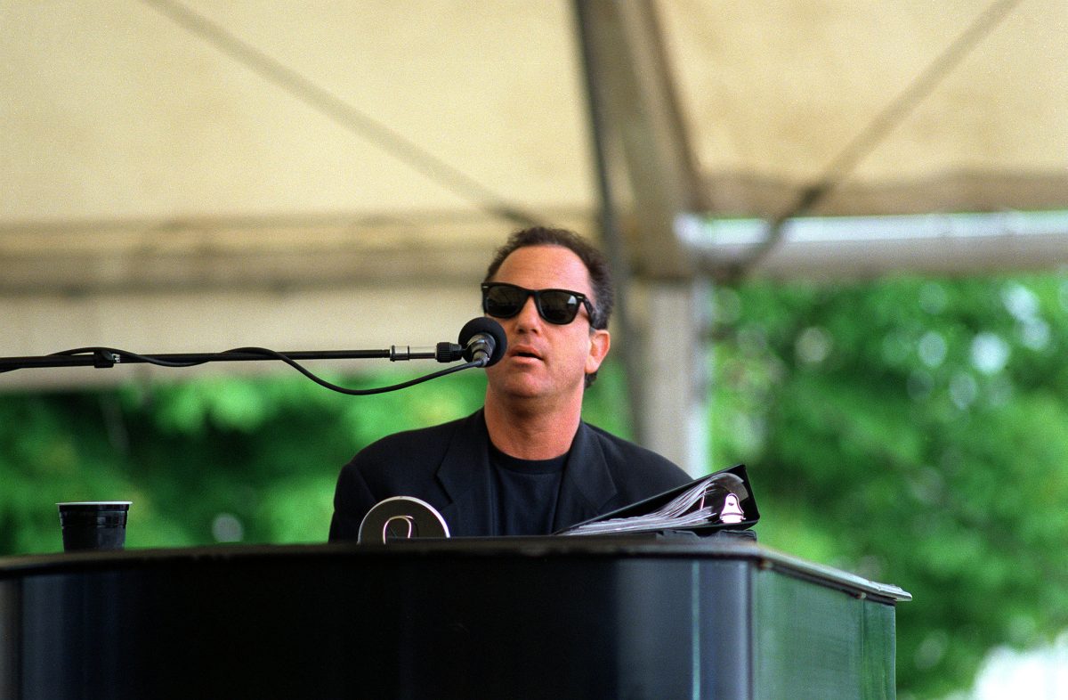 Billy Joel al piano, con gafas de sol, en un concierto de 1994