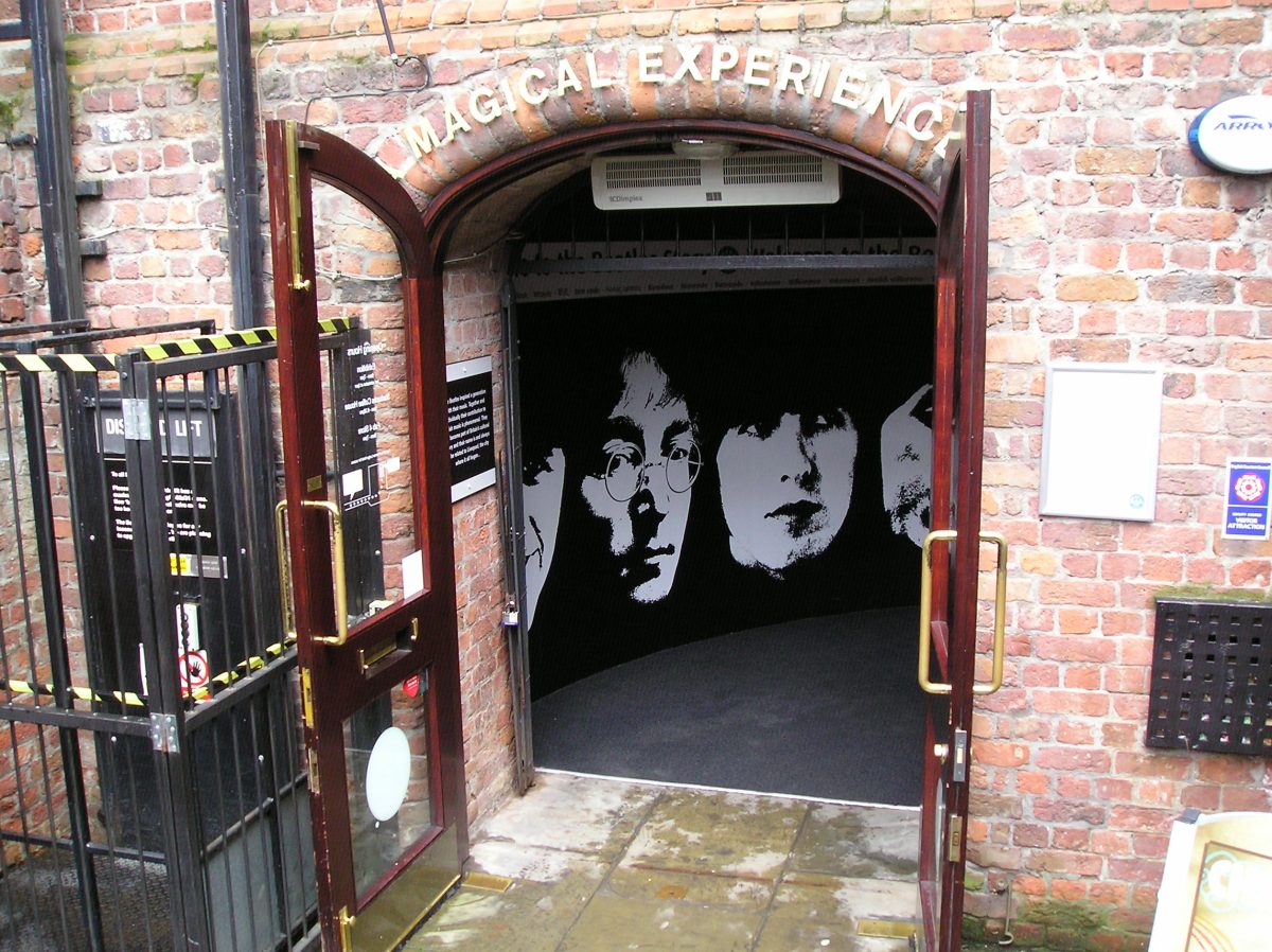 Entrada de The Beatles Story en el Albert Dock de Liverpool, con los rostros de los Beatles al fondo