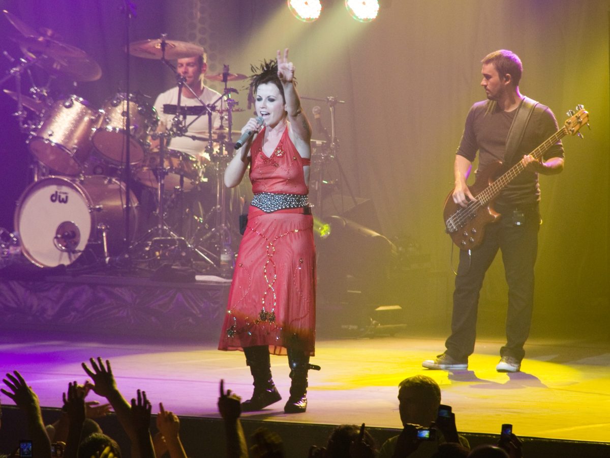 Dolores O'Riordan con The Cranberries en un concierto en París en 2010, con el batería y el bajista detrás